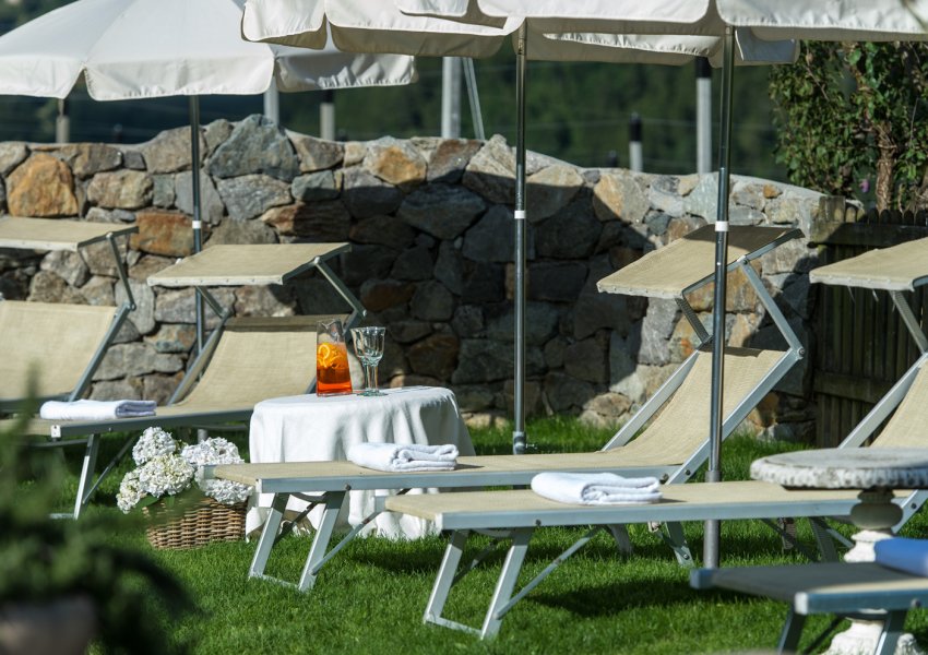 Liegestühle & Schirme in der Liegewiese am Schwimmbad des 3 Sterne Hotel Chalet Gravenstein mit Pool bei Meran